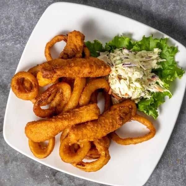 Fried fish and onion rings with a side of coleslaw and lettuce on a white plate.